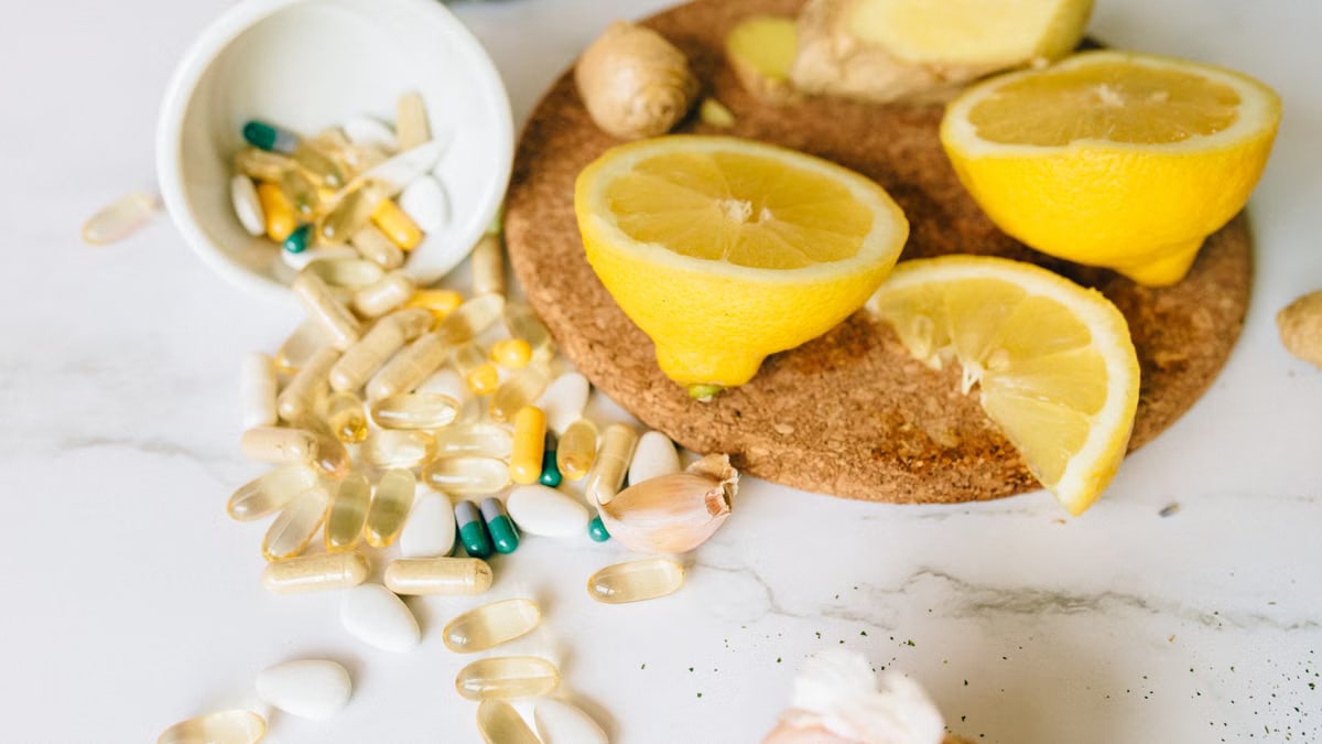 Sliced lemons and various supplements on a corkboard, symbolizing natural health remedies.